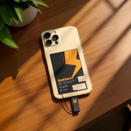 A slim card-sized battery pack charging a phone on a desk