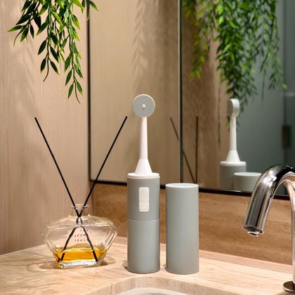 An electric toothbrush and its charging stand on a bathroom counter