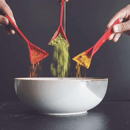 Silicone tongs lifting a portion of noodles out of a bowl