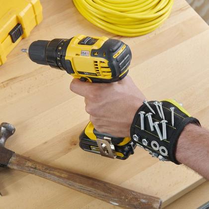 A magnetic wristband holding screws while a drill is in use
