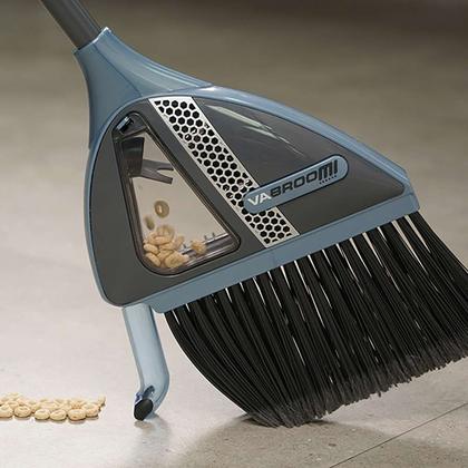 A broom with a rubber squeegee edge sweeping a hard floor