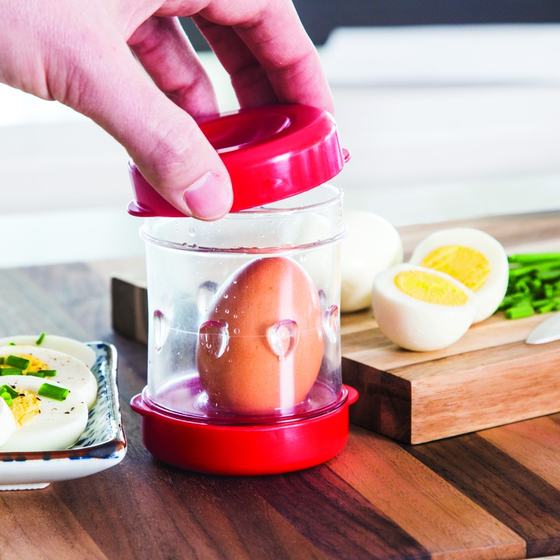The Negg egg peeler beside a peeled hard boiled egg